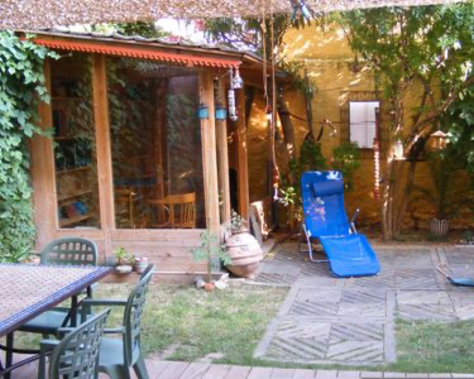 Jardin du gîte avec table extérieure et transat bleu